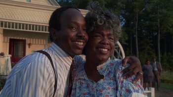Movie still from “The Color Purple” (1985), directed by Steven Spielberg – An older man and a younger woman posing for a picture; Close Up shot, Low angle