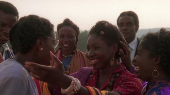 Movie still from “The Color Purple” (1985), directed by Steven Spielberg – A group of people that are standing together in the grass; Close Up shot, Over the shoulder angle