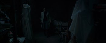 Movie still from “The Conjuring 2” (2016), directed by James Wan – A man standing in the dark in a room; Wide shot, High angle