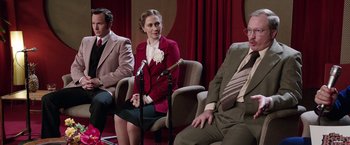 Movie still from “The Conjuring 2” (2016), directed by James Wan – A woman in a red jacket is sitting on a chair; Medium shot, Over the shoulder angle