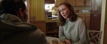 Movie still from “The Conjuring 2” (2016), directed by James Wan – A woman sitting at a table with a cup of coffee; Medium shot, Over the shoulder angle