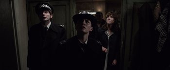 Movie still from “The Conjuring 2” (2016), directed by James Wan – A group of people standing in a room; Medium shot, Low angle