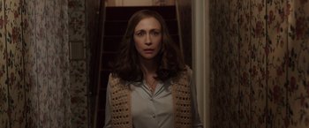 Movie still from “The Conjuring 2” (2016), directed by James Wan – A woman standing in front of a set of stairs; Medium shot, Over the shoulder angle