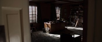 Movie still from “The Conjuring 2” (2016), directed by James Wan – A room with a wooden table and a clock on the wall; Extreme Wide shot, High angle