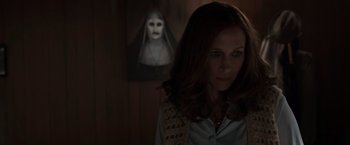 Movie still from “The Conjuring 2” (2016), directed by James Wan – A woman standing in front of a painting of a nun; Close Up shot, Over the shoulder angle