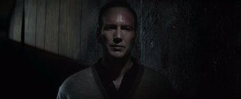 Movie still from “The Conjuring 2” (2016), directed by James Wan – A man in a dark room wearing a sweater; Close Up shot, Over the shoulder angle