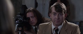 Movie still from “The Conjuring 2” (2016), directed by James Wan – A man in a brown suit and a man in a brown tie; Close Up shot, Over the shoulder angle