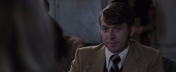 Movie still from “The Conjuring 2” (2016), directed by James Wan – A person wearing a suit and tie; Close Up shot, Over the shoulder angle