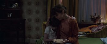 Movie still from “The Conjuring 2” (2016), directed by James Wan – A woman and a child sitting on a couch; Medium shot, Over the shoulder angle