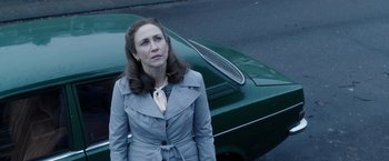 Movie still from “The Conjuring 2” (2016), directed by James Wan – A woman standing in front of a car on the side of the road; Medium shot, Low angle