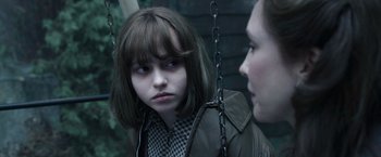 Movie still from “The Conjuring 2” (2016), directed by James Wan – A young girl sitting next to a woman on a swing; Close Up shot, Over the shoulder angle
