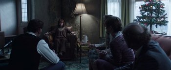 Movie still from “The Conjuring 2” (2016), directed by James Wan – A group of people sitting around a living room; Wide shot, High angle