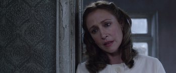 Movie still from “The Conjuring 2” (2016), directed by James Wan – A person standing near a wall; Close Up shot, Over the shoulder angle
