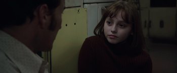 Movie still from “The Conjuring 2” (2016), directed by James Wan – A young girl wearing a brown sweater looking at a man in a brown jacket; Close Up shot, Over the shoulder angle