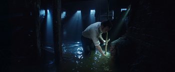 Movie still from “The Conjuring 2” (2016), directed by James Wan – A man in white shirt and black pants standing in water; Wide shot, High angle