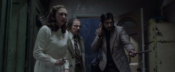 Movie still from “The Conjuring 2” (2016), directed by James Wan – A group of people standing next to each other in a room; Medium shot, Low angle