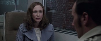 Movie still from “The Conjuring 2” (2016), directed by James Wan – A woman in a blue jacket is looking at the camera; Close Up shot, Over the shoulder angle