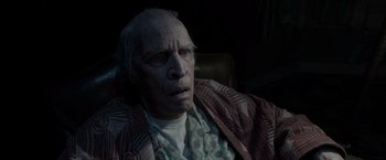 Movie still from “The Conjuring 2” (2016), directed by James Wan – An old man sitting in a chair wearing a robe; Close Up shot, High angle