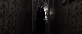 Movie still from “The Conjuring 2” (2016), directed by James Wan – A woman dressed as a nun in a dark hallway; Wide shot, Overhead angle