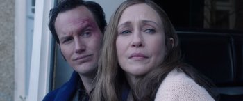 Movie still from “The Conjuring 2” (2016), directed by James Wan – A man and a woman looking at the camera; Close Up shot, Over the shoulder angle