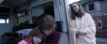 Movie still from “The Conjuring 2” (2016), directed by James Wan – A woman and a girl sitting next to each other on a train; Medium shot, Over the shoulder angle