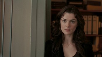 Movie still from “The Constant Gardener” (2005), directed by Fernando Meirelles – A beautiful woman with long dark brown hair looking out a window; Close Up shot, Over the shoulder angle
