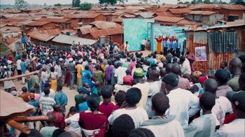 Movie still from “The Constant Gardener” (2005), directed by Fernando Meirelles – A group of people standing in front of a building; Extreme Wide shot, High angle