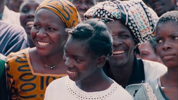 Movie still from “The Constant Gardener” (2005), directed by Fernando Meirelles – A group of women standing next to each other smiling; Medium shot, High angle