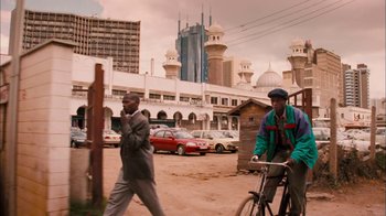 Movie still from “The Constant Gardener” (2005), directed by Fernando Meirelles – Two men walking down the street with a bicycle; Wide shot, Low angle