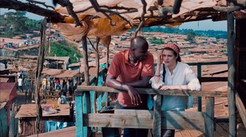 Movie still from “The Constant Gardener” (2005), directed by Fernando Meirelles – A man and a woman standing next to each other on top of a wooden structure; Medium shot, High angle