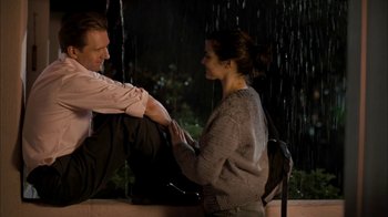 Movie still from “The Constant Gardener” (2005), directed by Fernando Meirelles – A man and a woman sitting on a bench in the rain; Medium shot, Over the shoulder angle