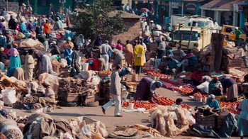Movie still from “The Constant Gardener” (2005), directed by Fernando Meirelles – A group of people standing around a market; Extreme Wide shot, High angle