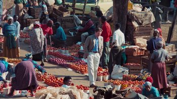 Movie still from “The Constant Gardener” (2005), directed by Fernando Meirelles – A group of people standing around a market with lots of tomatoes; Wide shot, High angle
