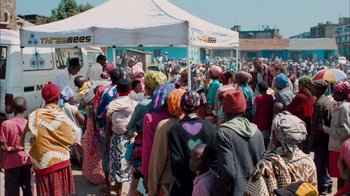 Movie still from “The Constant Gardener” (2005), directed by Fernando Meirelles – A group of people standing under a white tent; Extreme Wide shot, High angle