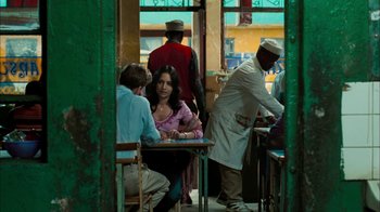Movie still from “The Constant Gardener” (2005), directed by Fernando Meirelles – A group of people sitting at a table in front of a window; Medium shot, Over the shoulder angle