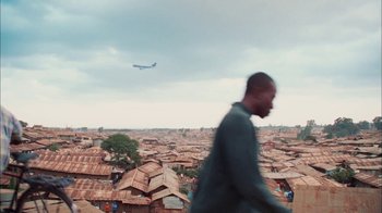Movie still from “The Constant Gardener” (2005), directed by Fernando Meirelles – A man is walking in the middle of a city; Extreme Wide shot, Low angle
