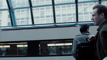 Movie still from “The Constant Gardener” (2005), directed by Fernando Meirelles – A person standing in front of a train window; Wide shot, Low angle