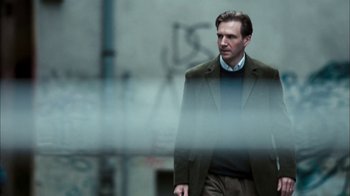 Movie still from “The Constant Gardener” (2005), directed by Fernando Meirelles – A man wearing a suit and tie standing in front of a building; Medium shot, Low angle