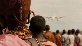 Movie still from “The Constant Gardener” (2005), directed by Fernando Meirelles – A group of people standing in front of an airplane; Close Up shot, Over the shoulder angle
