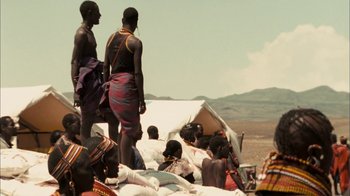 Movie still from “The Constant Gardener” (2005), directed by Fernando Meirelles – A group of men standing on top of a pile of sand bags; Wide shot, Over the shoulder angle