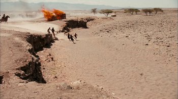 Movie still from “The Constant Gardener” (2005), directed by Fernando Meirelles – A group of people standing on top of a dirt field; Extreme Wide shot, High angle