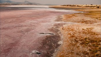Movie still from “The Constant Gardener” (2005), directed by Fernando Meirelles – A person walking along the shore of a beach; Extreme Wide shot, High angle