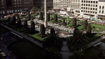 Movie still from “The Conversation” (1974), directed by Francis Ford Coppola – People are walking around a park in the middle of a city; Extreme Wide shot, High angle