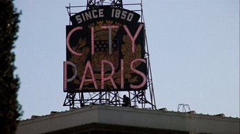 Movie still from “The Conversation” (1974), directed by Francis Ford Coppola – A large neon sign on the side of a building; Extreme Wide shot, Low angle