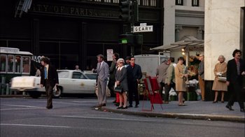 Movie still from “The Conversation” (1974), directed by Francis Ford Coppola – A group of people standing on the side of the street; Wide shot, High angle