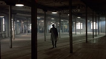 Movie still from “The Conversation” (1974), directed by Francis Ford Coppola – A person walking in a large room with lights on; Extreme Wide shot, High angle