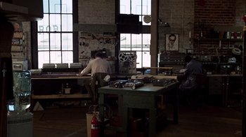 Movie still from “The Conversation” (1974), directed by Francis Ford Coppola – A man working in a workshop on a table; Wide shot, High angle