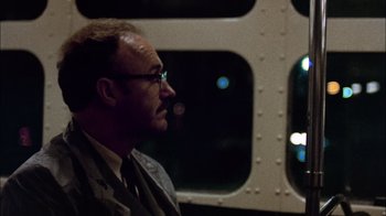 Movie still from “The Conversation” (1974), directed by Francis Ford Coppola – A man with a beard and glasses sitting on a bus; Close Up shot, Low angle