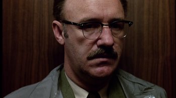 Movie still from “The Conversation” (1974), directed by Francis Ford Coppola – An older man with a mustache wearing glasses; Close Up shot, Low angle