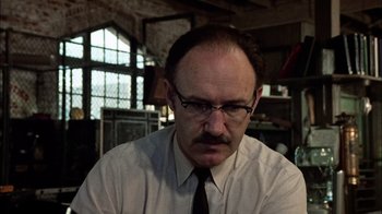 Movie still from “The Conversation” (1974), directed by Francis Ford Coppola – A man with a beard and glasses sitting in front of a window; Close Up shot, Low angle